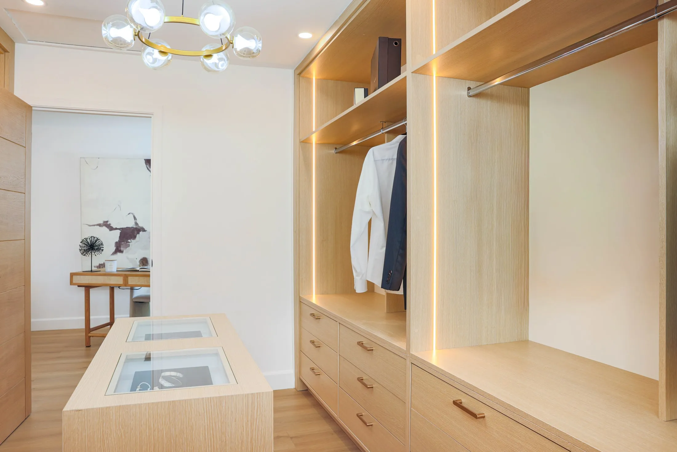 Full view of the custom walk-in closet with hanging rails and island drawers