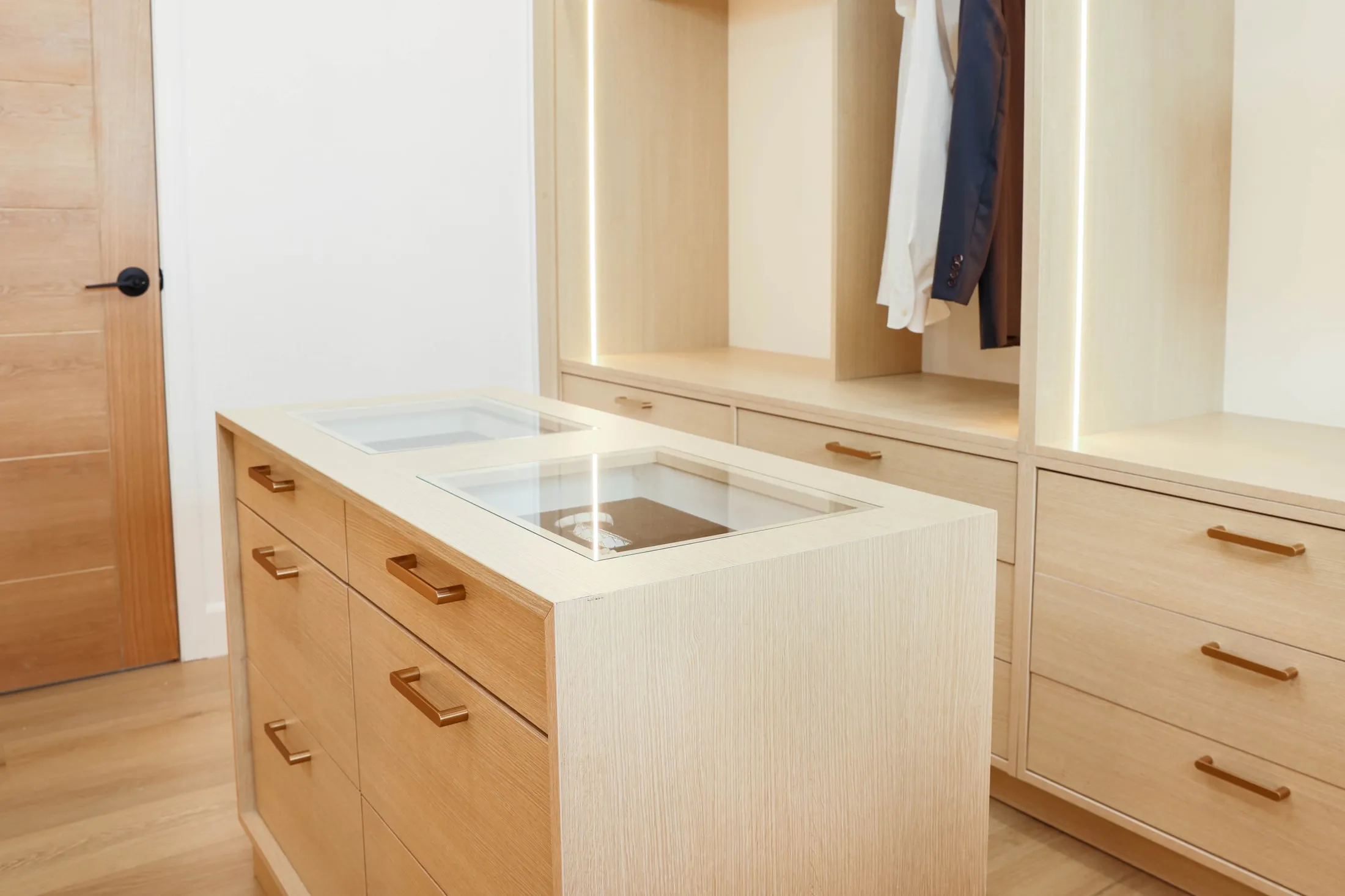 Glass-topped closet island with accessory display and storage drawers